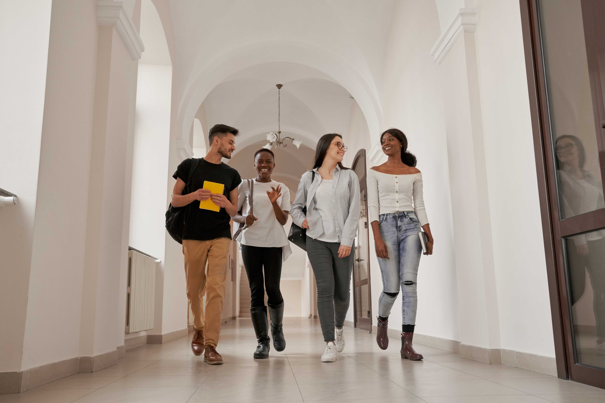 Happy student group walking up hallway